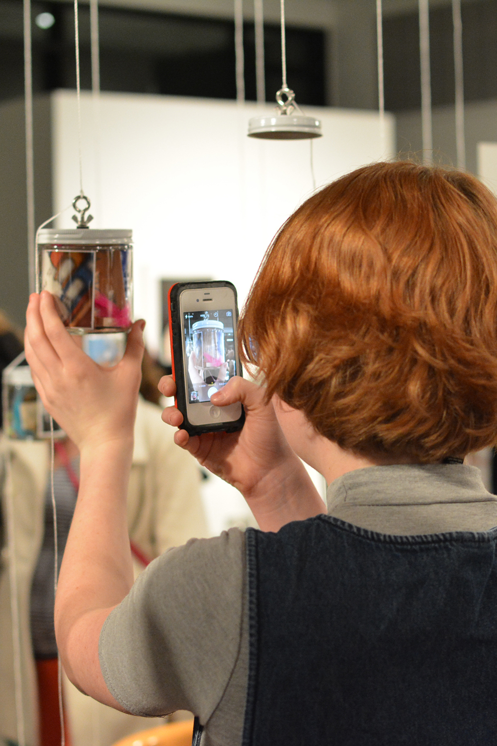 A visitors taking a photograph of the jar she made, after putting it on display.